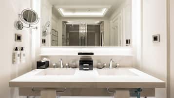 A modern bathroom with a large mirror, two sinks, and a towel rack.