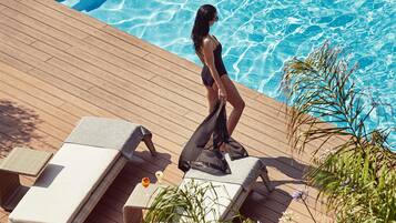 Ein Poolbereich mit Liegestühlen und einer Holzterrasse.