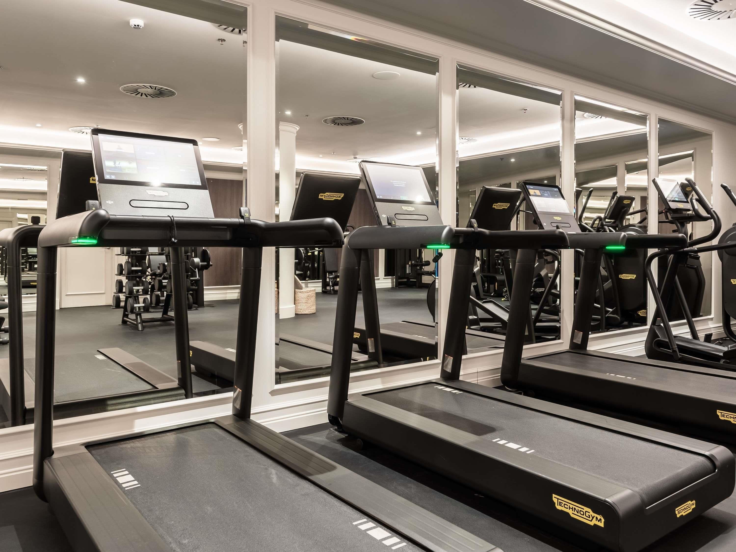 Et fitnesscenter med løbebånd, styrkemaskiner og konditionsudstyr.