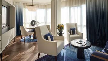 A modern living room with a television, seating, and a dining area.