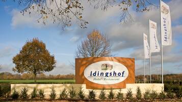 A sign for Idingshof Hotel & Restaurant with a clear view of the surrounding landscape.