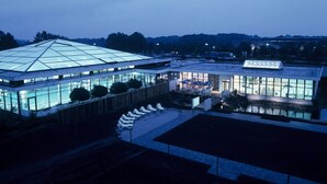 A modern building with a glass facade and a large, triangular roof.