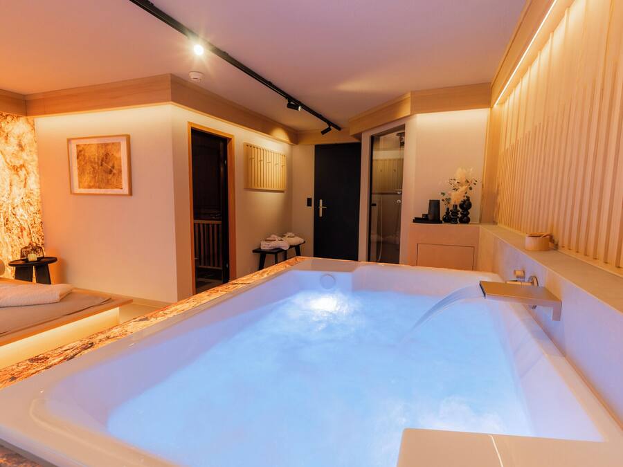 A modern spa room with a hot tub, wooden accents, and a minimalist design.