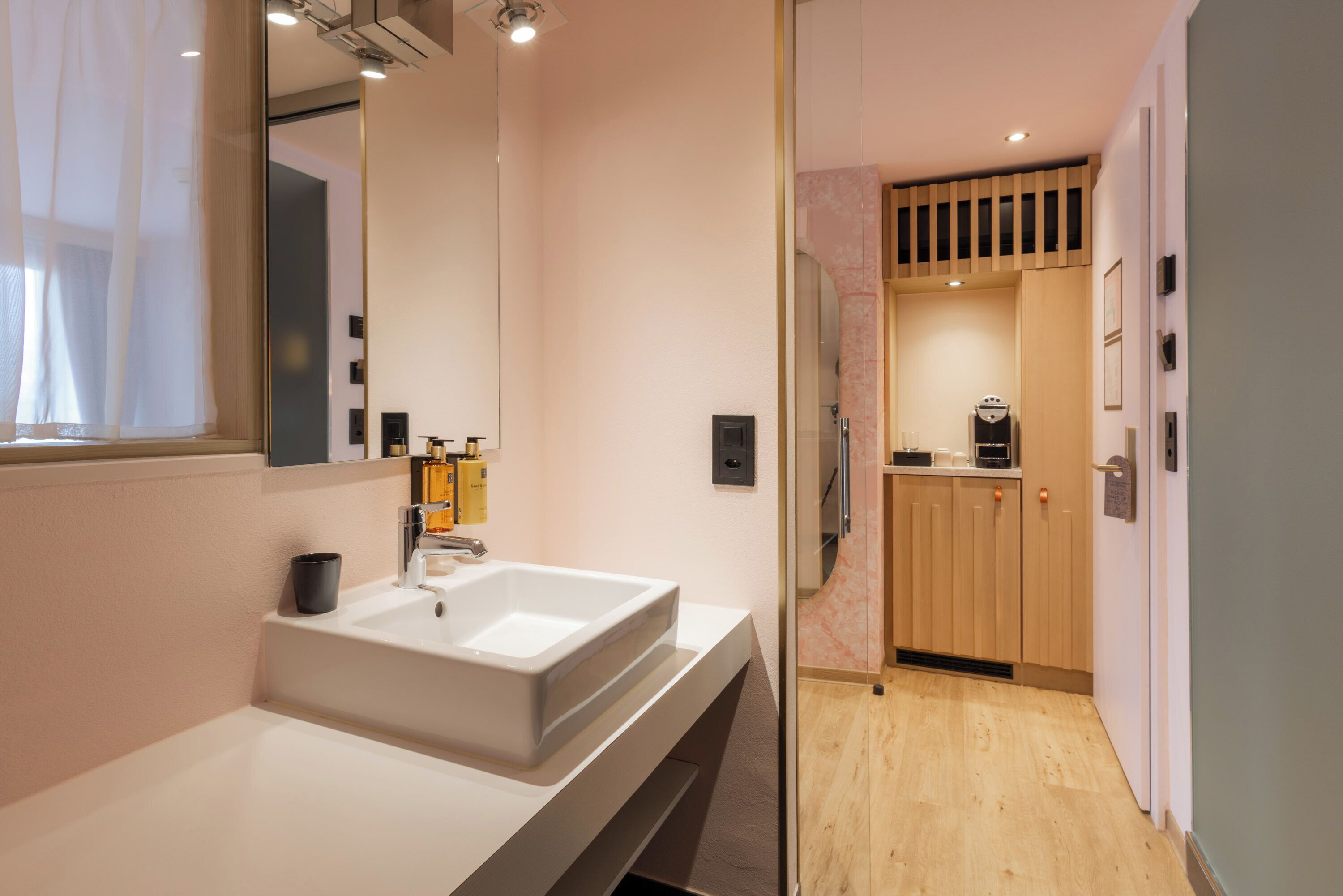 A modern bathroom with a large mirror, a white sink, and a shower area.