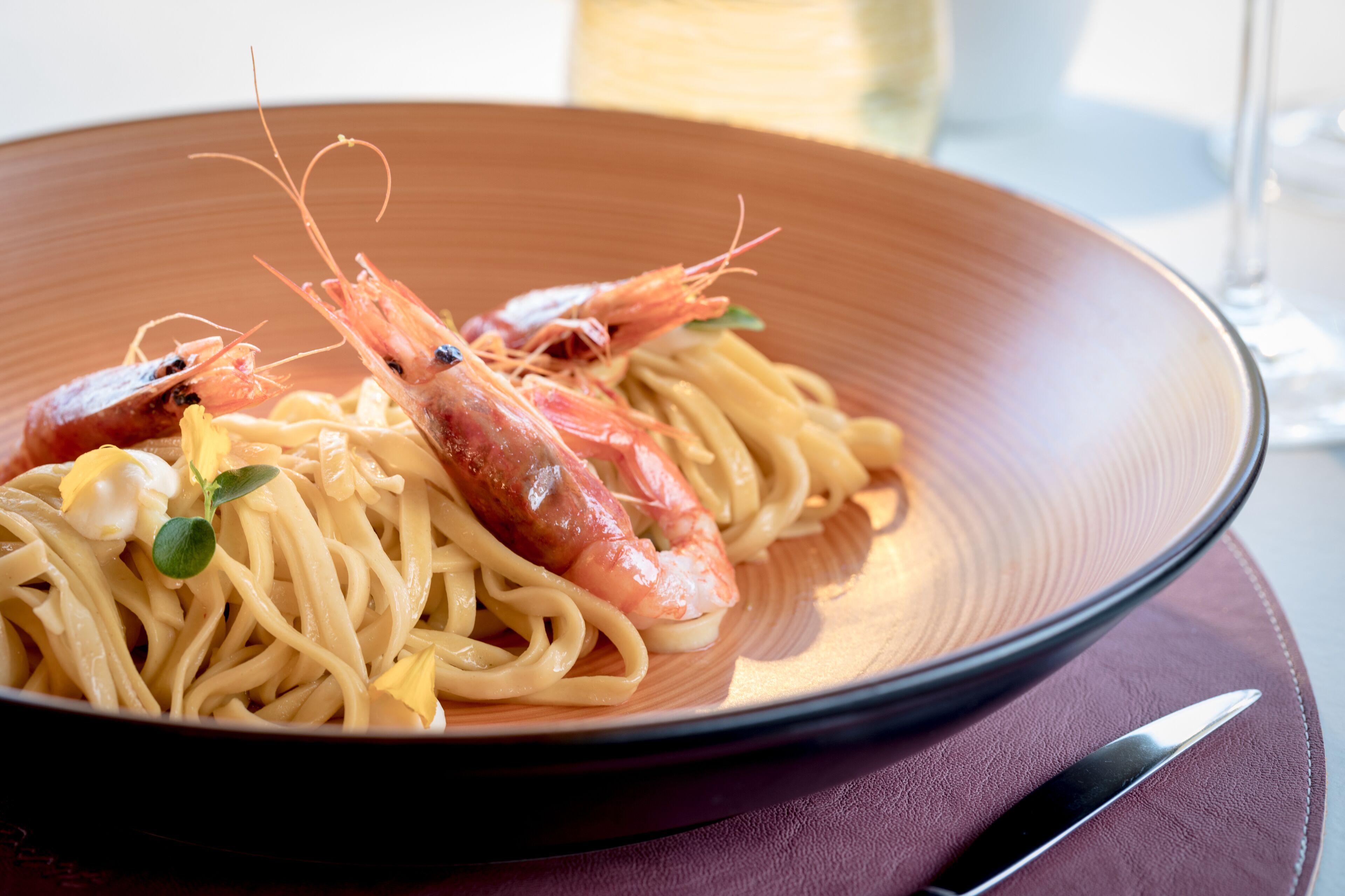 Une assiette de spaghettis aux crevettes, garnie.