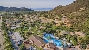 Um resort com piscina, vilas e vista para o mar.