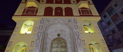 A building with intricate architectural details, including a large arched entrance and decorative patterns on the facade.
