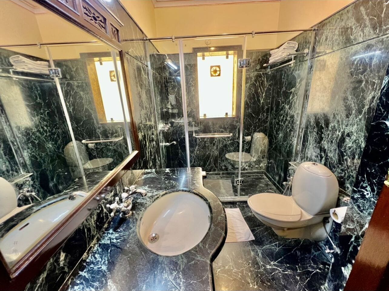 A bathroom with a marble sink, toilet, and shower.