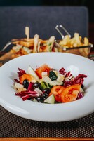 Uma salada de folhas verdes variadas com croutons e uma porção de batatas fritas.
