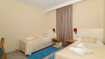 A hotel room with two beds, a desk, and a chair.