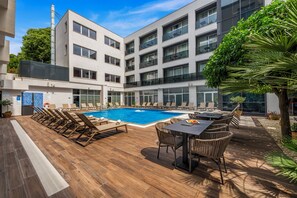 A modern hotel with a pool area, outdoor seating, and a view of the building's exterior. - Hotel Lero (Dubrovnik)