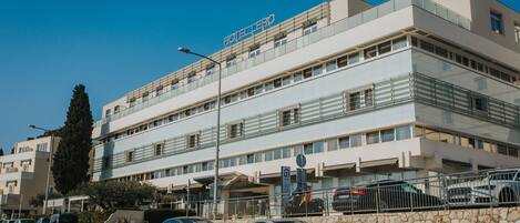 Et hotel i flere etager med et moderne arkitektonisk design, der har et markant skilt med "HOTEL LERO" øverst.