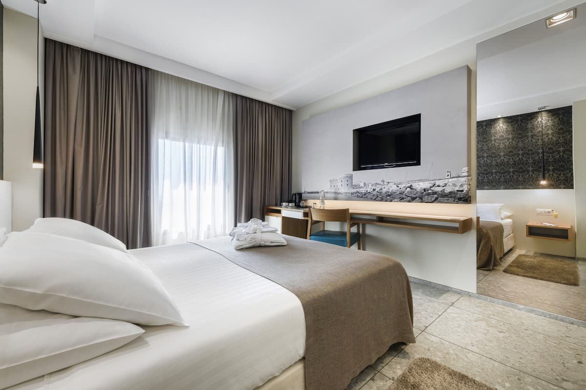 Ein Hotelzimmer mit einem Bett, einem Schreibtisch, einem Fernseher und einem Badezimmer.