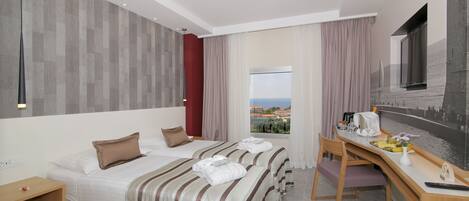 Une chambre d’hôtel avec deux lits, un bureau, une chaise, une fenêtre donnant sur un paysage agréable et un téléviseur à écran plat.