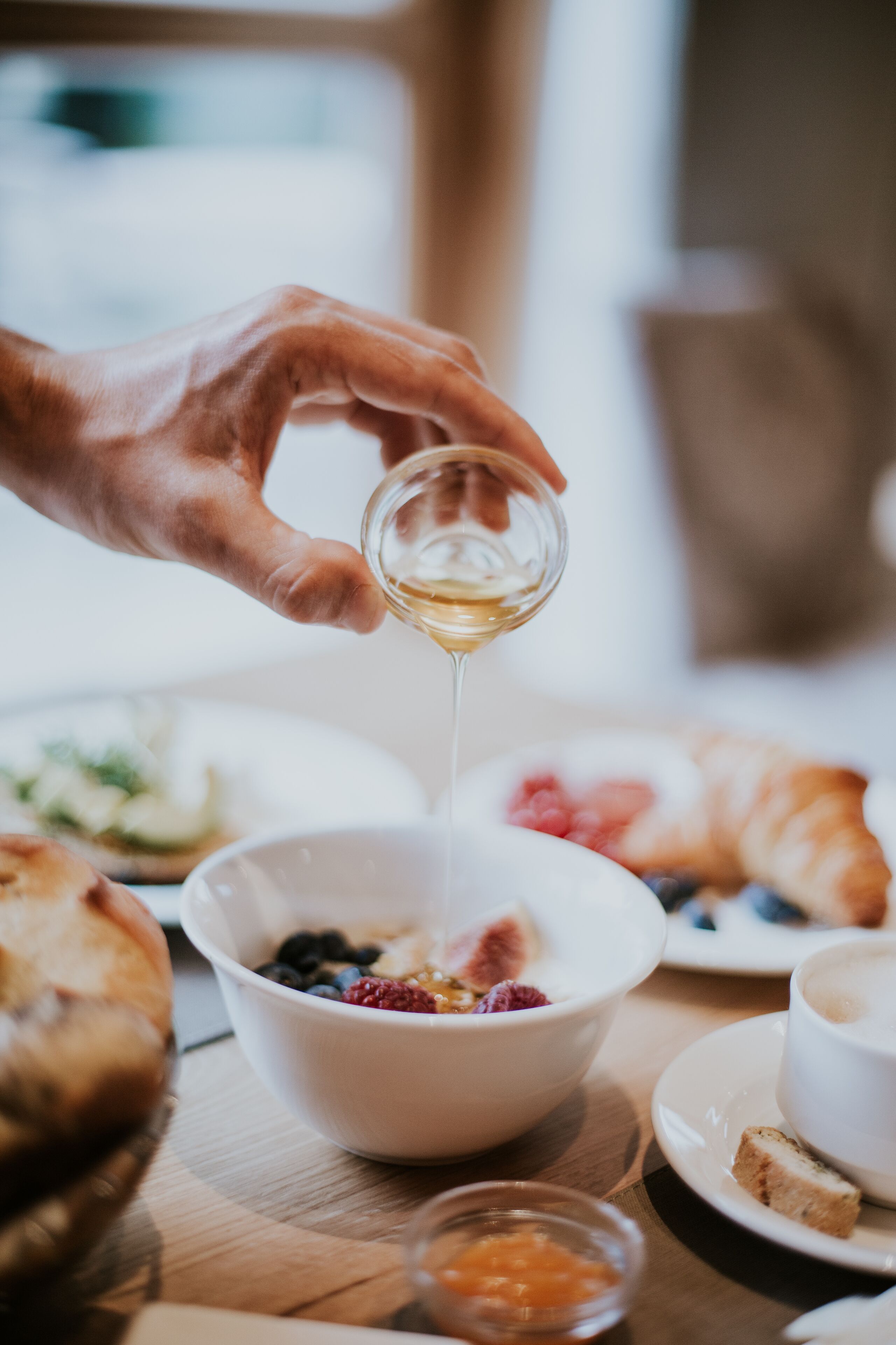 Eine Hand gießt ein Getränk in eine Schüssel mit Essen.