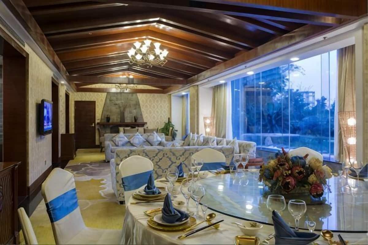 Un comedor con una mesa redonda para cuatro personas, un sofá y una chimenea.