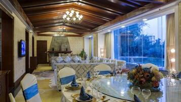 A dining area with a round table set for four, a sofa, and a fireplace.