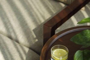 A glass of water with a lemon slice on a wooden tray on a cushioned chair. - 88 Eling Park Hotel (Chongqing Eling Erchang) (Chongqing)