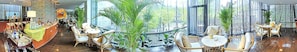 A spacious indoor area with multiple seating arrangements, including round tables and chairs, surrounded by large windows and indoor plants. - 88 Eling Park Hotel (Chongqing Eling Erchang) (Chongqing)