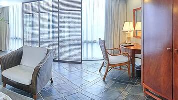 A hotel lobby with a fireplace, seating area, and a dining space.