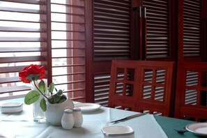A dining table set with plates, a vase with a red flower, salt and pepper shakers, and a knife. - 88 Eling Park Hotel (Chongqing Eling Erchang) (Chongqing)