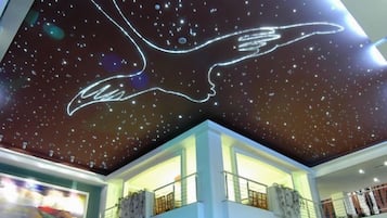 A ceiling with a starry night sky design and a winged figure.