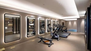 A modern gym with mirrored walls, treadmills, and weight machines. - JI Hotel (Baizhang East Road Ningbo) (Ningbo)