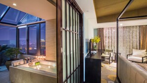 Een moderne hotelkamer met een groot bad, een bank en een eethoek.
