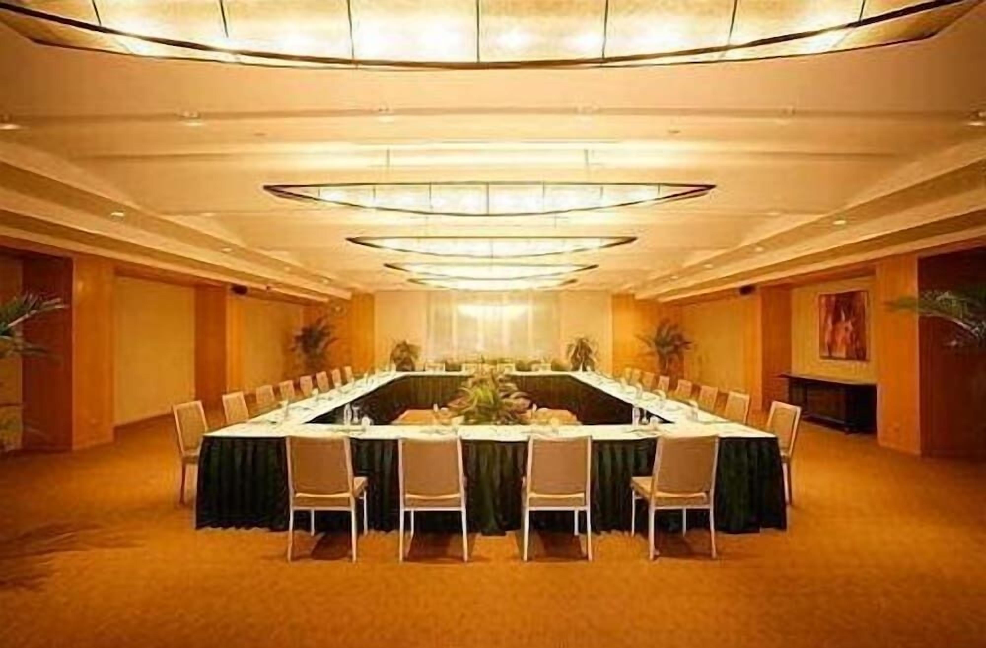 A conference room with a long table, chairs, and a chandelier.