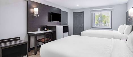A modern hotel room with a bed, a desk, a television, and a window with a view.