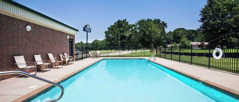 A rectangular swimming pool with a brick wall and a sign indicating 'Daytime Pool'.