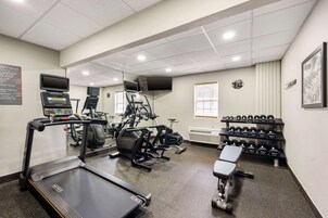 Un gimnasio con cintas de correr, elípticas y mancuernas.