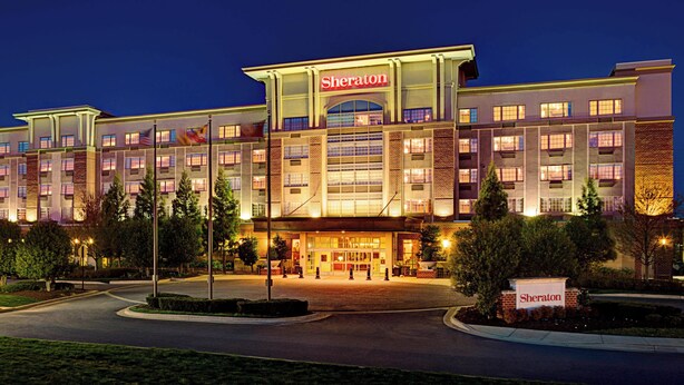A Sheraton hotel with a modern facade, multiple floors, and a well-lit entrance.