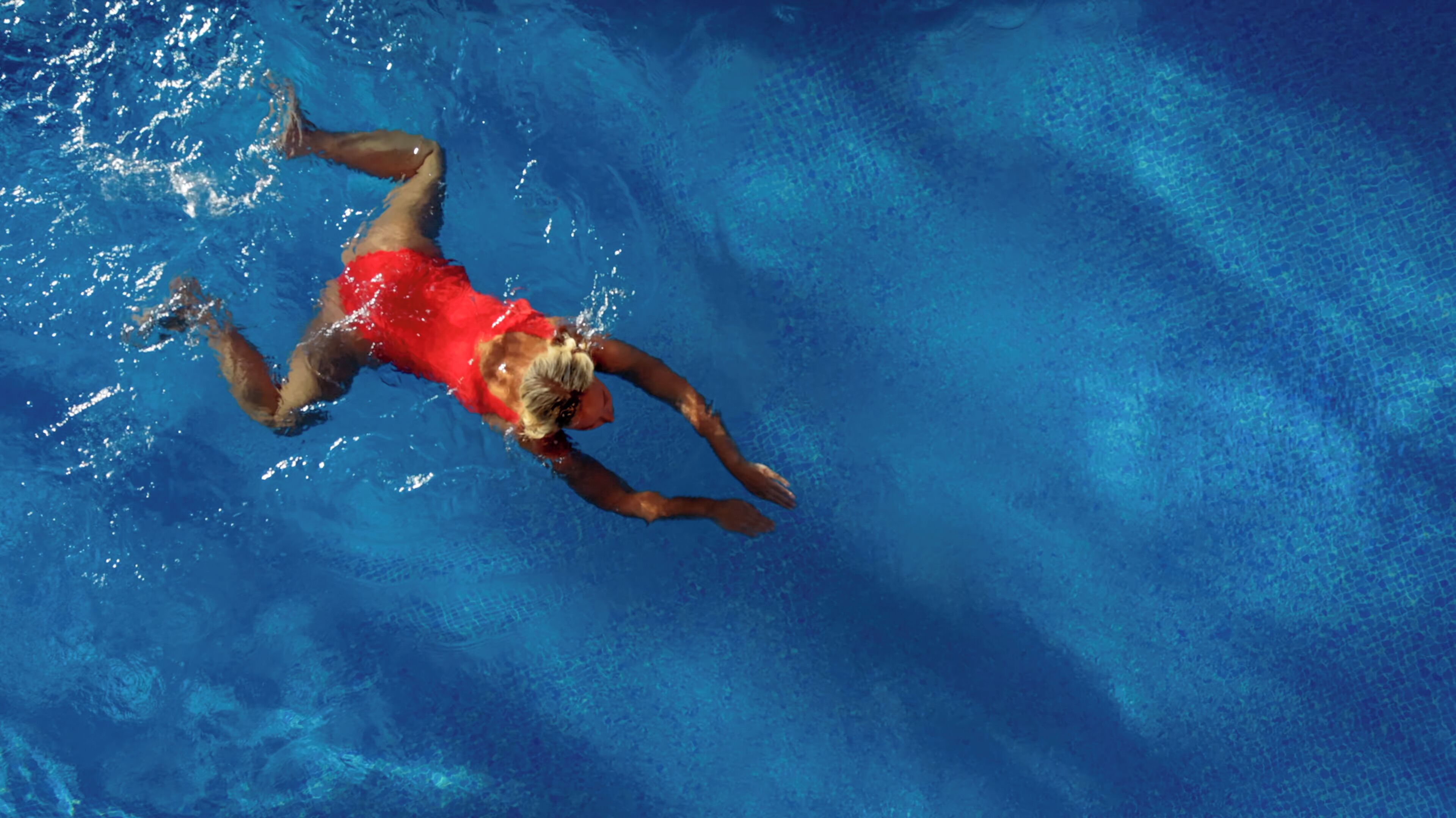 Una persona nadando en una piscina.
