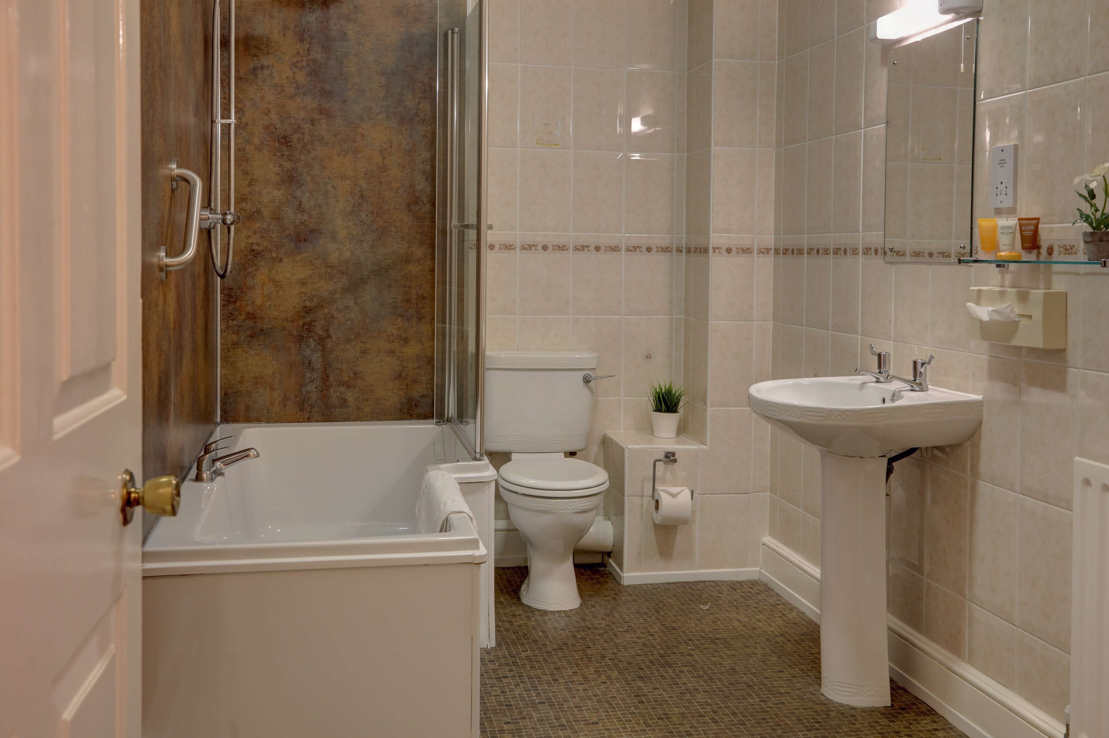 A bathroom with a bathtub, toilet, and sink.