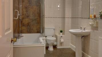 A bathroom with a bathtub, toilet, and sink.