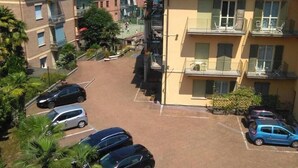 A multi-story residential building with a parking area in front. - Azalea Hotel (Baveno)