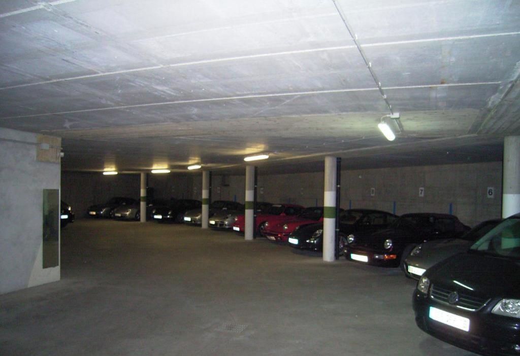 Un estacionamiento subterráneo de varios niveles con varios coches aparcados.