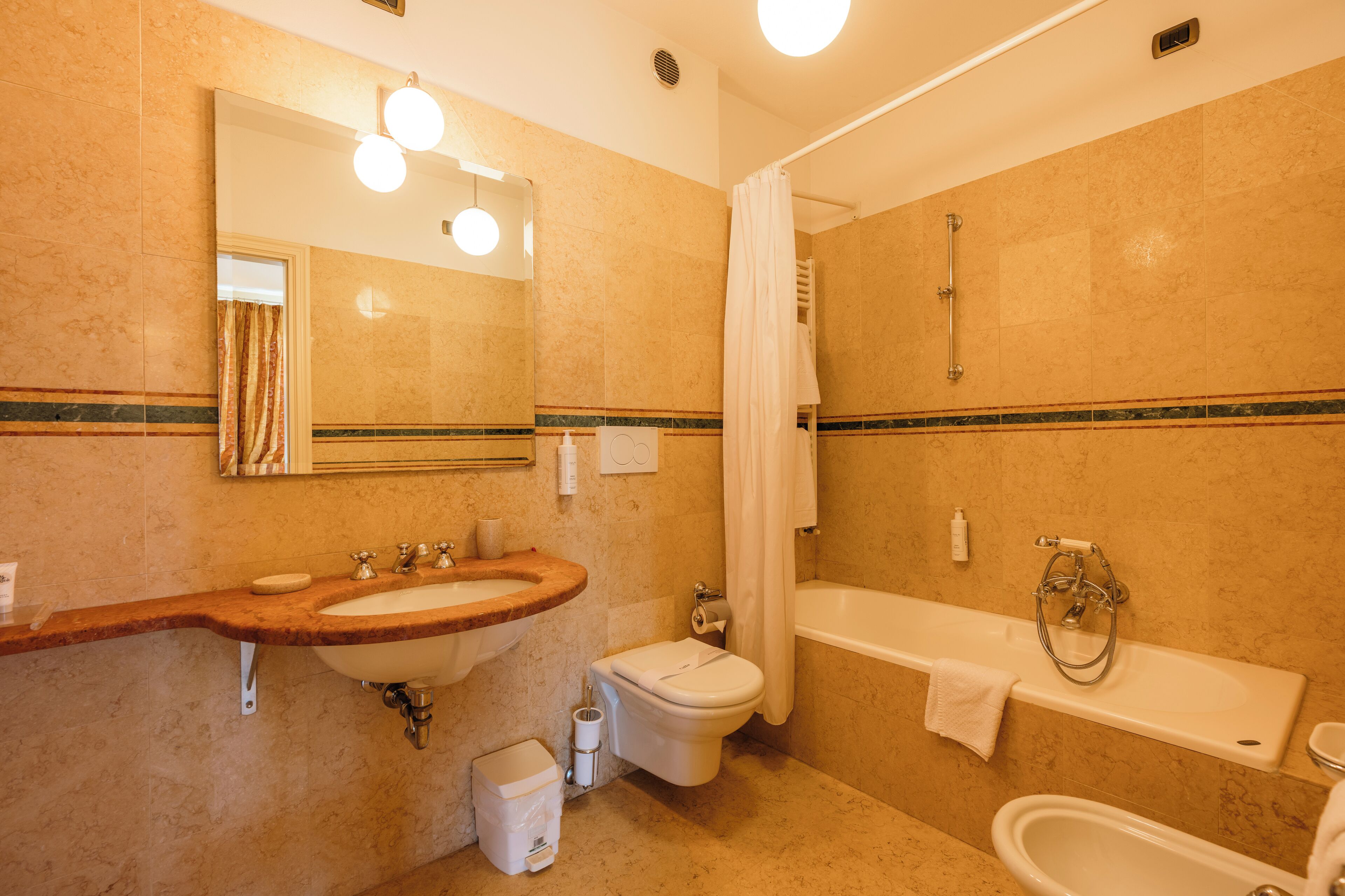 A bathroom with a sink, toilet, and bathtub.