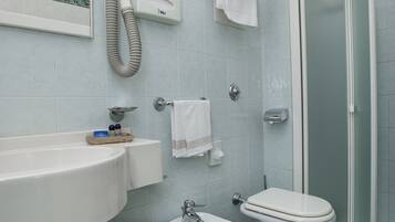 Ein Badezimmer mit Waschbecken, Bidet, Toilette und Duschbereich.