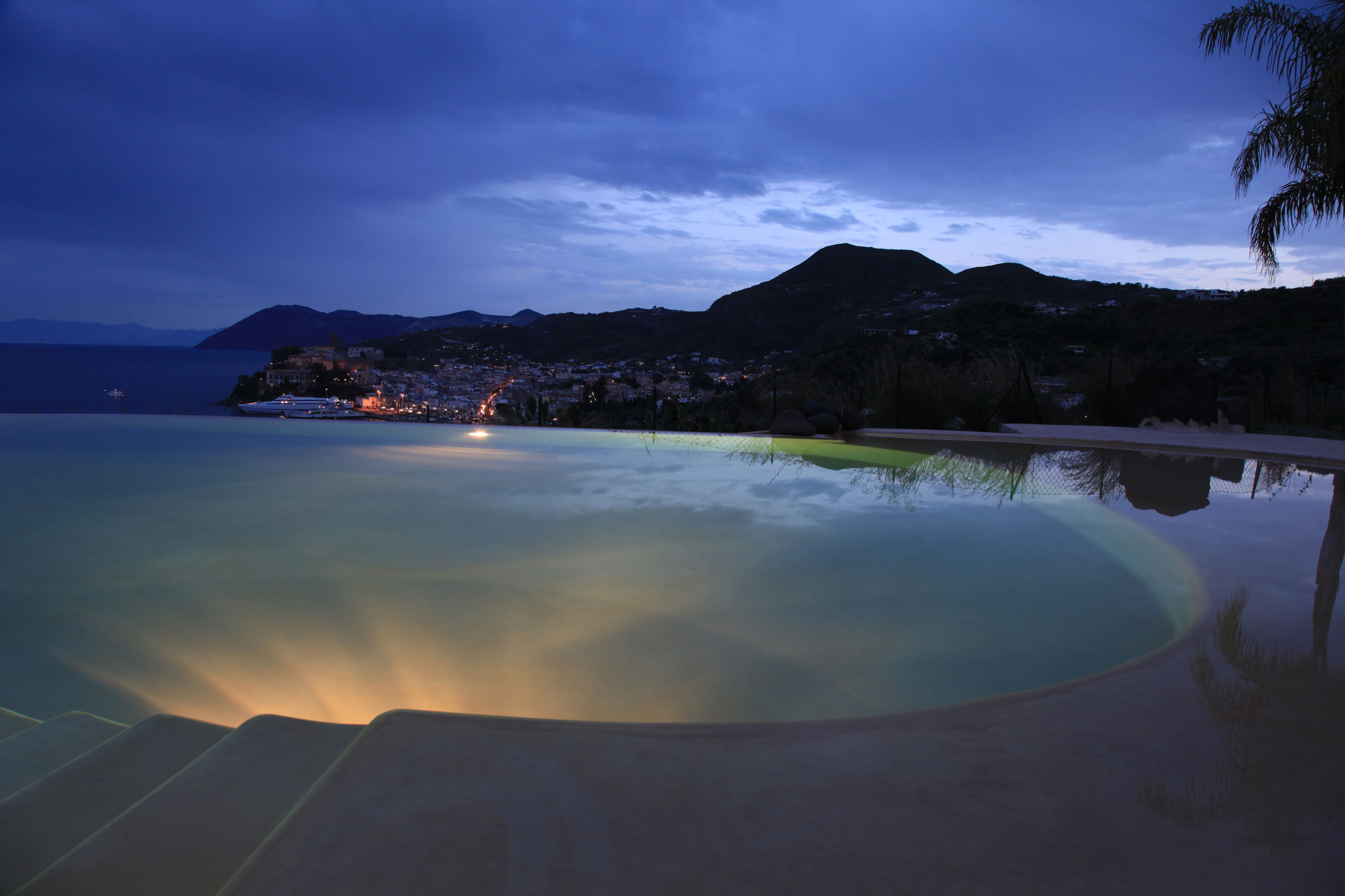 Ein ruhiger Poolbereich mit freiem Blick auf die umliegende Landschaft, darunter ein Berg und eine ferne Stadt.