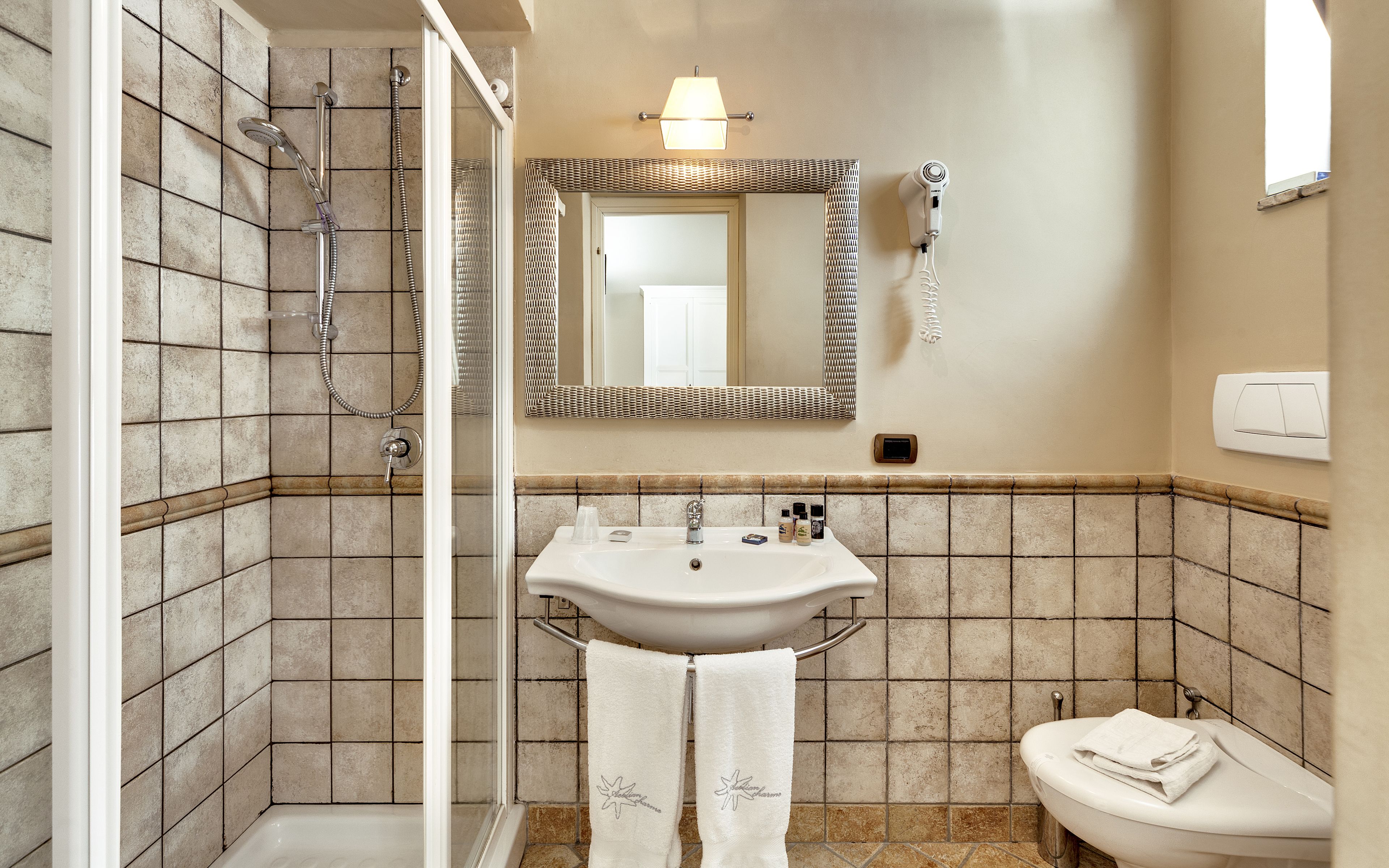 A bathroom with a shower, sink, and toilet.
