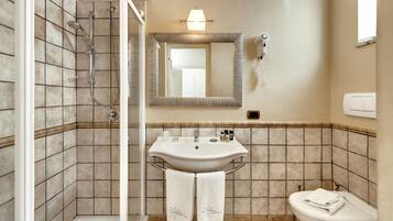 A bathroom with a shower, sink, and toilet.