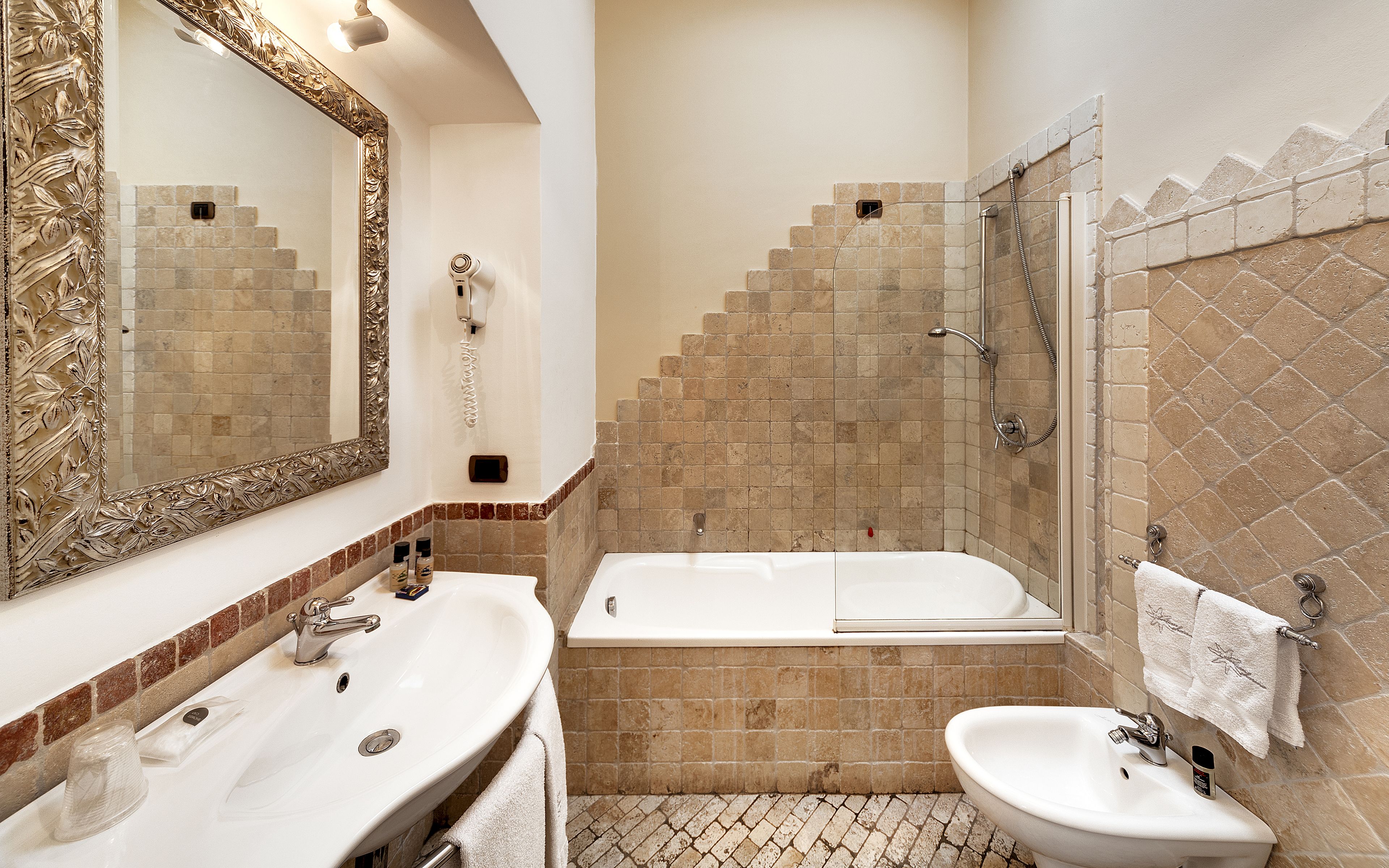 A bathroom with two sinks, a bathtub, and a shower.