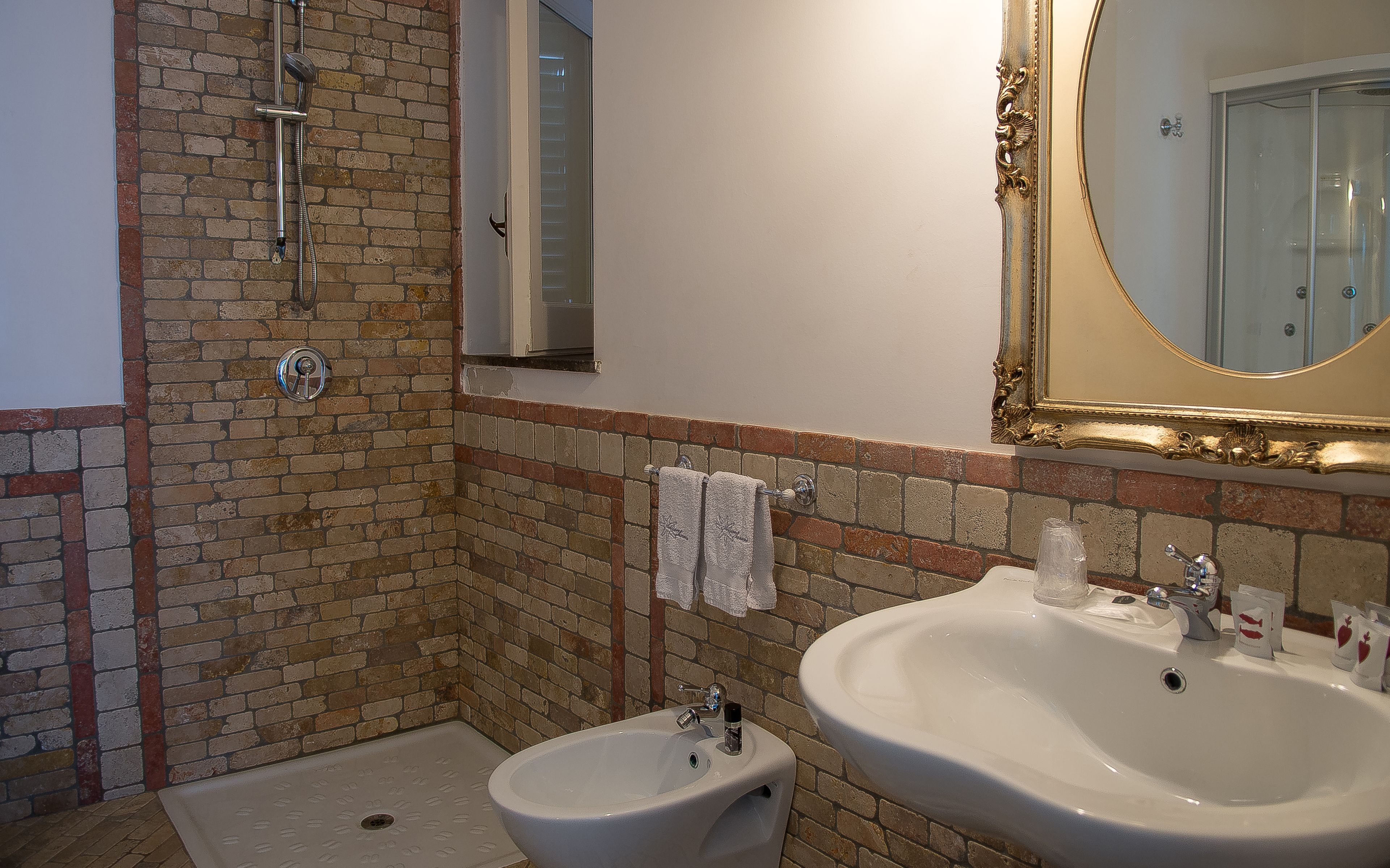 A bathroom with a shower, two sinks, and a mirror.