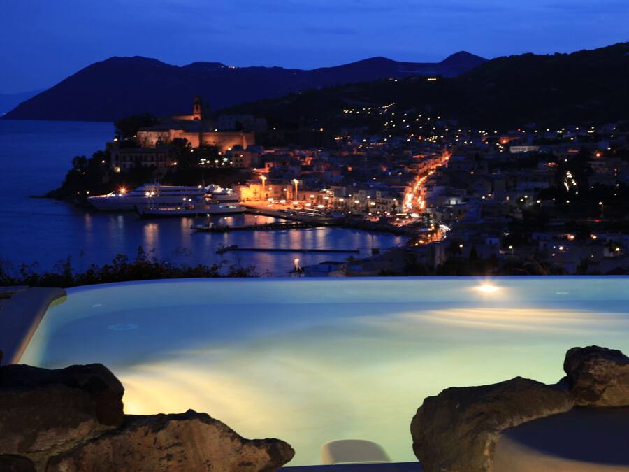 Een buitenzwembad, ligstoelen bij het zwembad