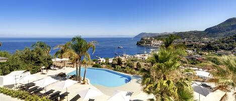 Een buitenzwembad en ligstoelen