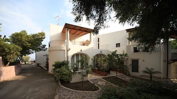 Un edificio con un vialetto in pietra, finestre ad arco e un balcone.