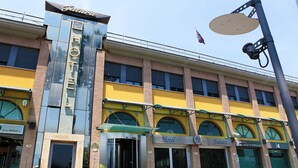 Et hotel med en moderne facade, store vinduer og en markant indgang.