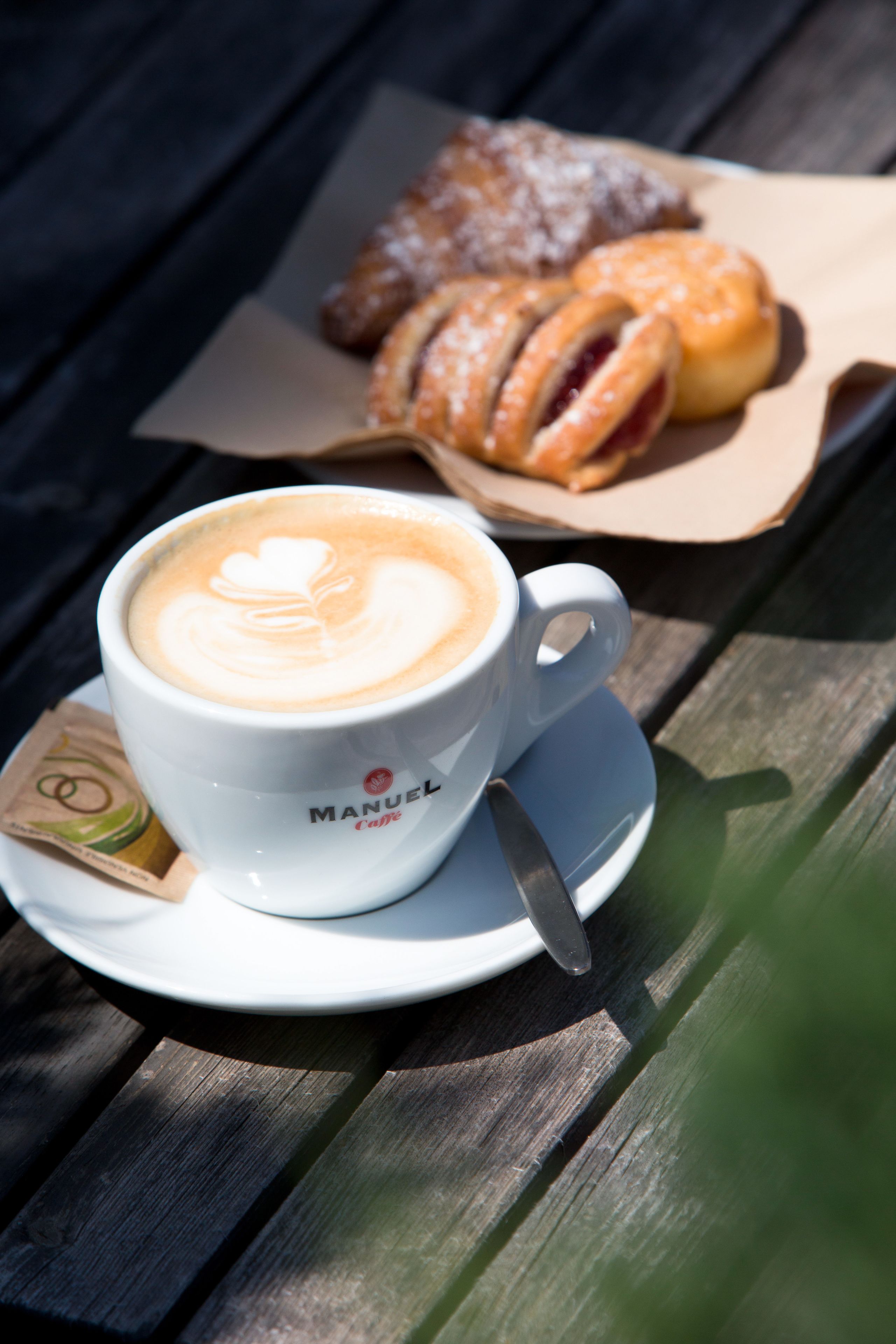 A cup of coffee with latte art on a wooden table.